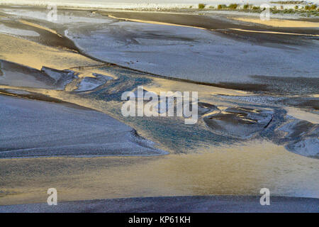 Abstrakte natürliche Bild, auf dem Fluss, die Oberfläche des Wassers spiegelt die goldenen Farbe der Sonne, blaue Wasser, viel Grün im Hintergrund. Stockfoto