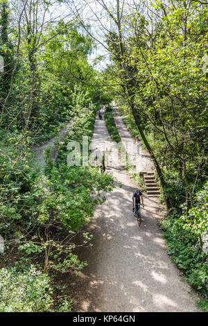 Wanderer und Radfahrer auf die Parklandschaft spazieren, eine stillgelegte Bahnstrecke, jetzt ein Schutzgebiet, im Norden von London, Großbritannien Stockfoto