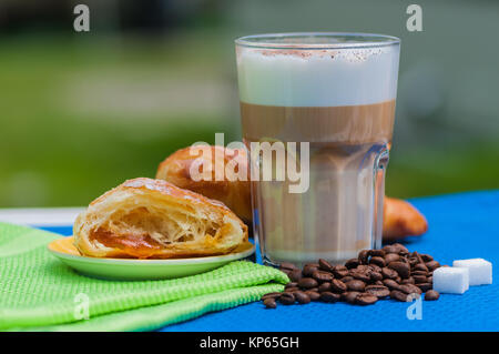 Kleines Frühstück im Garten mit frischen Croissants und Cappuccino Stockfoto