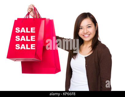 Asiatische Frau mit Einkaufstasche und zeigt drei Verkauf Wort Stockfoto