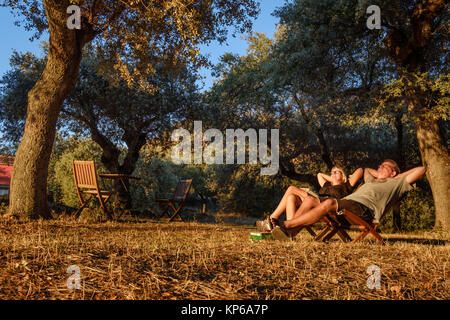 Entspannende, Gesunde, Männer und Frauen genießen den Sonnenuntergang auf einem natürlichen Hintergrund. Reisen, Camping, Tourismus Konzept. Stockfoto