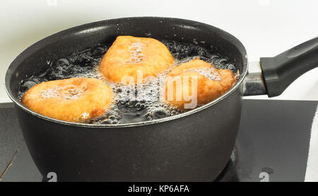 Nahaufnahme der Krapfen kochen in kochend heißem Öl in Wasserkocher Stockfoto