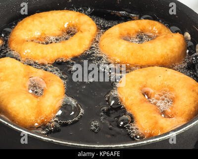 Nahaufnahme der Krapfen kochen in kochend heißem Öl in Wasserkocher Stockfoto