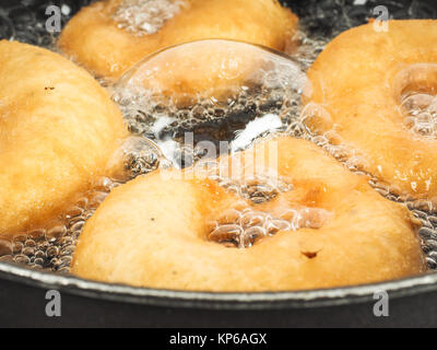 Nahaufnahme der Krapfen kochen in kochend heißem Öl in Wasserkocher Stockfoto