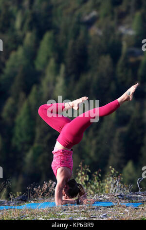 Frau Yoga und Meditation im Freien Handstand mit Splits. Saint-Gervais. Frankreich. Stockfoto