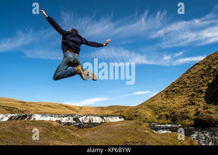 Springen in der Nähe von Wasserfall Seljalandsfoss. Island. Stockfoto