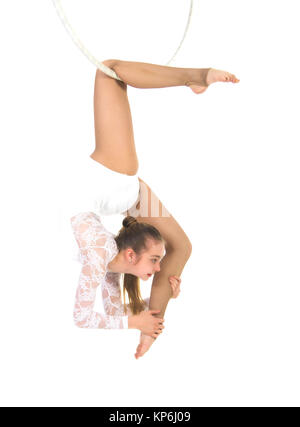 Eine junge Frau führt die akrobatischen Elemente im Luftring auf. Studio-Aufnahmen auf weißem Hintergrund. Stockfoto