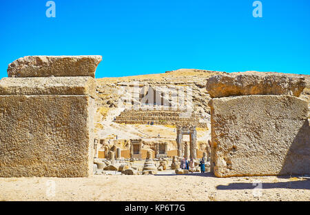 PERSEPOLIS, IRAN - Oktober 13, 2017: Der Blick auf die Artaxerxes III Grab, auf dem Berghang gelegen, durch den massiven Felsbrocken von Persepolis ar Stockfoto