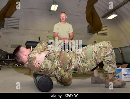 Staff Sgt. David Dillow, 386 Expeditionary medizinische Gruppe physikalische Therapie Techniker, lehrt Älterer Flieger Calvin Lourens, 386 Expeditionary Logistik Bereitschaft Squadron Passenger Service Specialist, Techniken zu helfen, seinen Schmerz Dez. 7, 2017, an einem geheimen Ort im Südwesten Asien entlasten. (U.S. Air Force Stockfoto