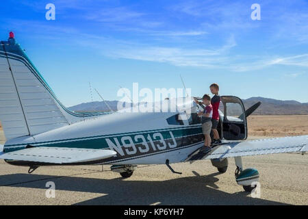 Kinder der Redlands Flughafen Gemeinschaftsstand auf der Flügel eines Flugzeugs in Spenden an die Twentynine Palms Airport Dez. 2, 2017 zu bringen. Dieses Ereignis markierte den dritten jährlichen Spielwaren für Tots Fly-in. (U.S. Marine Corps Stockfoto