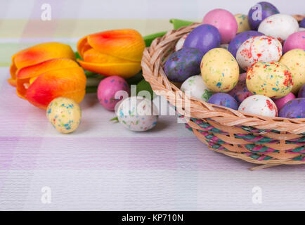 Ostern Süßigkeiten und Tulpen auf einem bunten Tischplatte Stockfoto