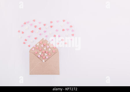 Rosa, Rot und Weiß Süßigkeiten Zucker candy Herz fliegen in Form von Herzen aus dem craft-Umschlag auf den weißen Hintergrund. Valentinstag Konzept. Stockfoto