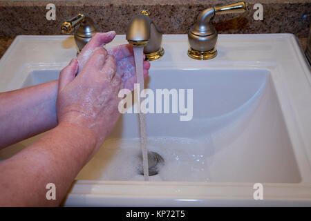 Nahaufnahme von Frau Waschen der Hände im Waschbecken im Bad. Stockfoto