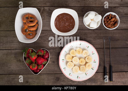 Schokolade, Obst und Keksen auf dem hölzernen Tisch Stockfoto