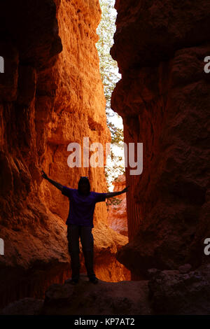 Wanderer in schmalen Canyon am Queens Garden Wanderweg Posing, Bryce Canyon Ntl. Park, Utah, USA Stockfoto