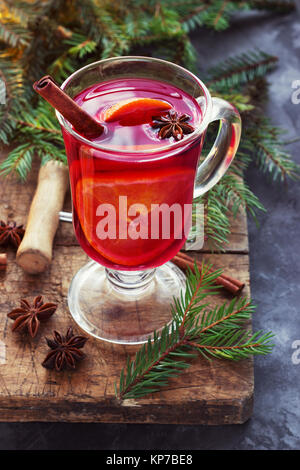 Wein mit Gewürzen und Weihnachtsbaum auf Holz- hintergrund Glühwein Stockfoto