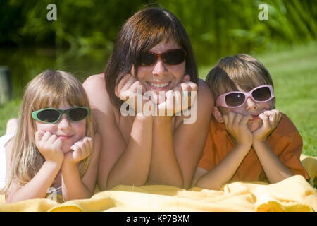 Model Release, Mit Sohn Und Tochter Stück Mit Sonnenbrillen in der Wiese - Mutter, Mutter, Sohn und Tochter mit Sonnenbrille Stockfoto