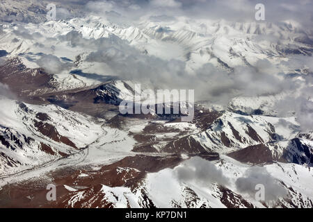 Winter Berglandschaft: Schneebedeckte Bergketten, braun Hänge der Berge, der Wolken über die Oberseiten der Gletscher. Stockfoto