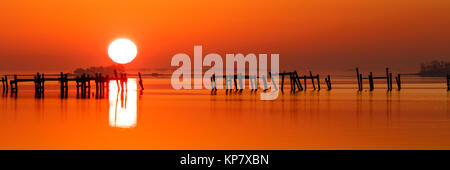 Sonnenaufgang auf Assateague Insel Chincoteague Wildlife Refuge mit Dock und Pylone Silhouette Stockfoto