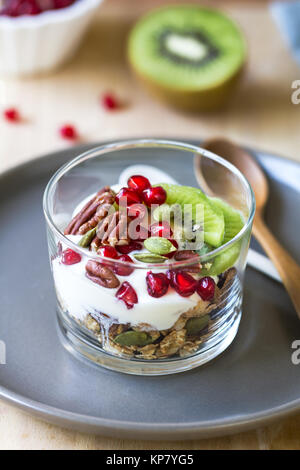 Müsli mit griechischem Joghurt, Kiwi und Granatapfel Stockfoto