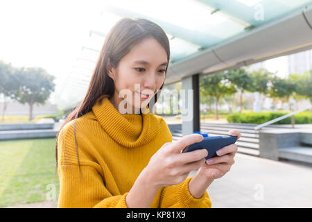 Asiatische Frau spielen das Spiel auf Handys Stockfoto