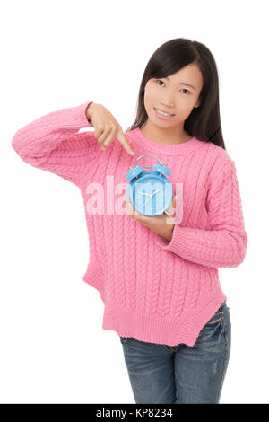 Schöne chinesische Frau mit und zeigen auf einen blauen Wecker auf weißem Hintergrund Stockfoto