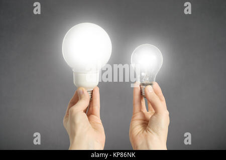 Hände mit Glühlampen Stockfoto