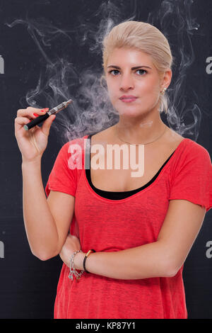 Junge attraktive blonde Frau Rauchen einer E-Zigarette Stockfoto