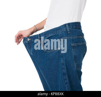 Frau, die Ihre alte Jeans zeigt Nach erfolgreicher Diät Stockfoto