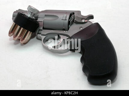 Eine rostfreie Stupsnase 44 spl-Revolver mit einer geladenen Speed loader Neben es auf einem weißen Hintergrund Stockfoto