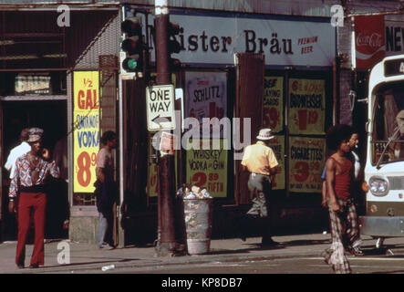 Street Scene an der 47. Straße in South Side von Chicago, einer belebten Gegend, wo viele kleine Schwarze Geschäfte befinden. Männer in 1970s Era Moden gesehen die Straße überqueren kann. Stockfoto