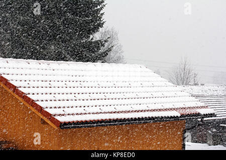 Schneefanghaken auf einem Hausdach schützen vor Dachlawinen bei starkem Schneefall Stockfoto