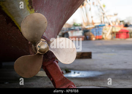 Die Schraube der ein Fischerboot im Hafen Workshop ausgestellt. Die Reparatur von beschädigten Fischerboote in der Werkstatt auf dem Port Wharf. Herbst Stockfoto