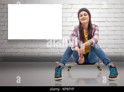 Schöne junge Frau mit einem Skateboard posiert, Sitz auf Skate Stockfoto