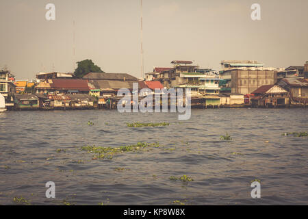 Hölzerne Slums auf Stelzen am Ufer des Chao Praya River in Bangkok, Thailand Stockfoto