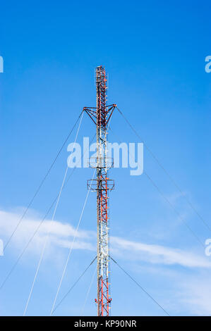 Große rote und weiße Antenne auf blauen Himmel Stockfoto