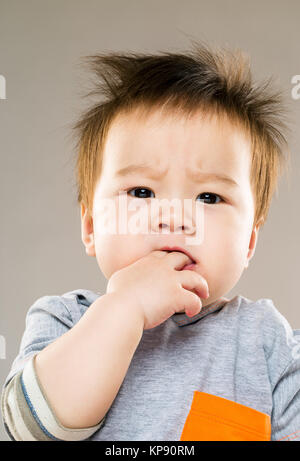 Baby Boy Finger im Mund Stockfoto