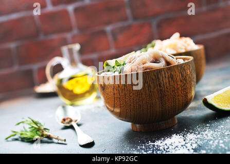 Rohen Tintenfisch in Schüsseln und auf einem Tisch Stockfoto