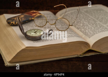 Altes Buch mit Brille und Taschenuhr Stockfoto