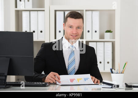 Happy Geschäftsmann Analyse der Diagramme Stockfoto