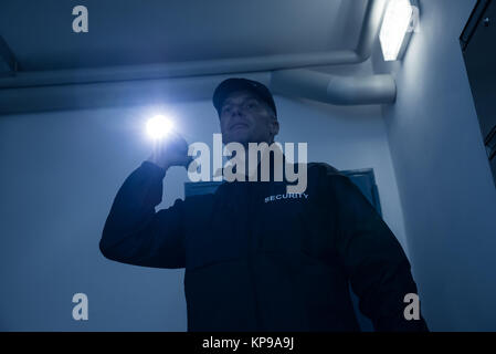 Sicherheit Schutz suchen mit Taschenlampe im Büro Stockfoto