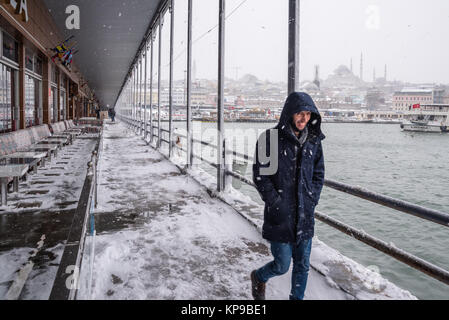 Unbekannter Mann gehen unter der Galatabrücke an einem verschneiten Tag im Winter. Istanbul, Türkei, 07. Januar 2017 Stockfoto