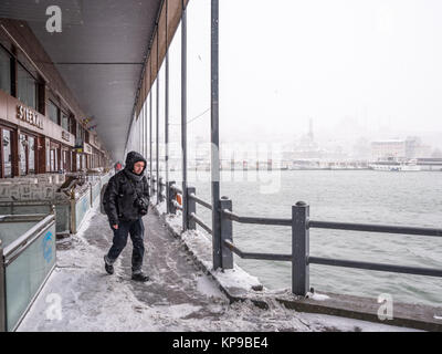 Unbekannter Mann gehen unter der Galatabrücke an einem verschneiten Tag im Winter. Istanbul, Türkei, 07. Januar 2017 Stockfoto