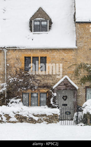Lower Slaughter Village Cottage während es schneit im Dezember. Lower Slaughter, Cotswolds, Gloucestershire, England Stockfoto