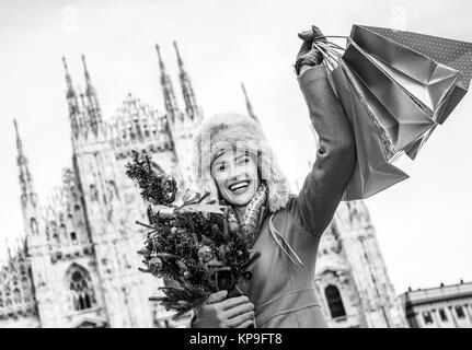 Lustige Weihnachten Reise nach Mailand, Italien. glückliche junge Reisende Frau in Mailand mit Weihnachtsbaum und Einkaufstaschen Jubel Stockfoto