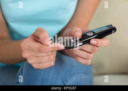 Frau mit Glucometer, Blutzuckerspiegel überprüfen Stockfoto