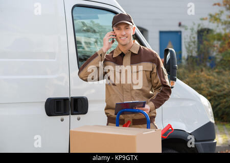 Lieferung Mann mit Handy gegen Lkw Stockfoto