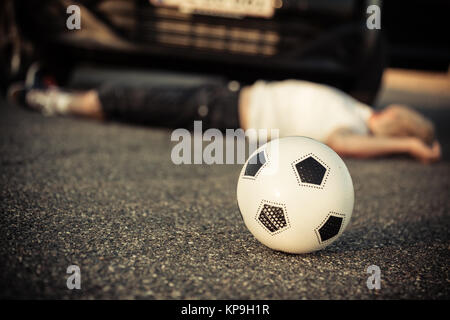 Jungen Fußball spielen von einem Auto angefahren Stockfoto