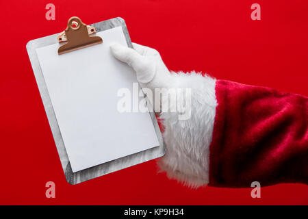 Santa Claus hand mit einem Klemmbrett mit leere Seite Stockfoto