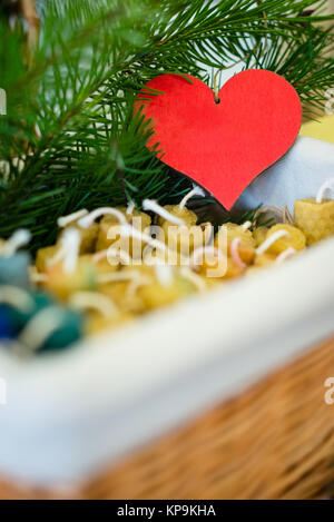 Box von Kerzen mit roten Herzen im Hintergrund Stockfoto